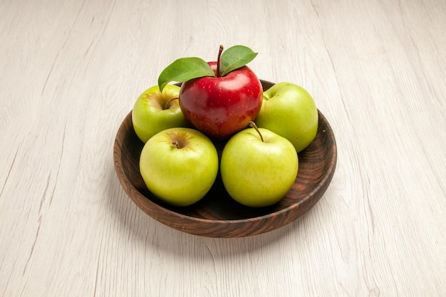 正面図新鮮な青リンゴ熟したまろやかな果物白い机の上の果物色木新鮮な植物赤