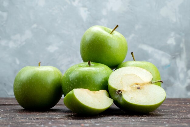 Front view fresh green apples sliced and whole on grey