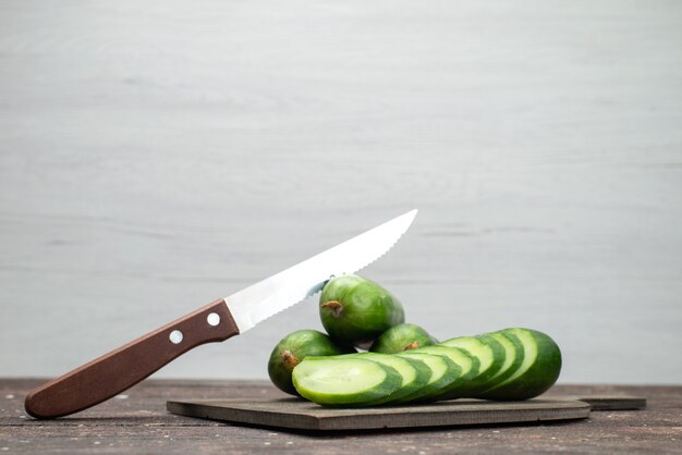 Front view fresh green cucumbers whole and sliced on white, vegetable food meal