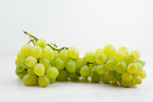 Вид спереди свежий зеленый виноград сочный и кислый на белом столе цвет фруктов витамин лето