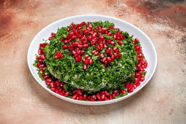 Front view fresh greens with peeled pomegranates on a light table fruit color green