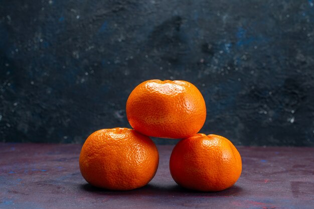 正面図新鮮なジューシーなみかんオレンジ色の暗い机の柑橘類の熱帯のエキゾチックなオレンジ色の果実