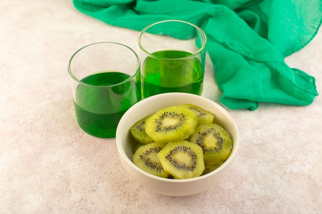 A front view fresh kiwi slices with green kiwi juice on the pink desk fruit exotic color drink