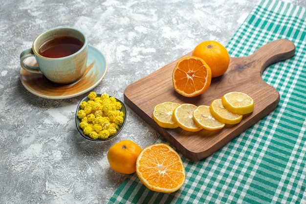 가벼운 표면에 사탕과 차 한잔과 함께 전면보기 신선한 레몬 조각