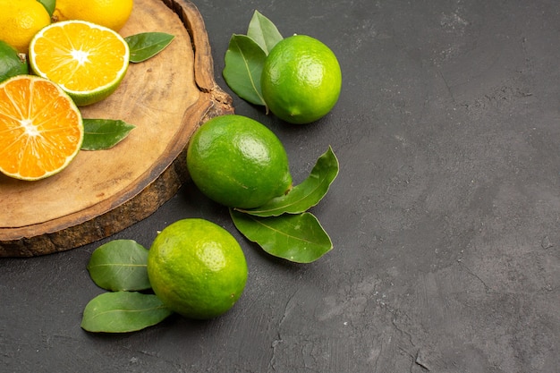 Бесплатное фото Вид спереди свежие лимоны на темном столе, фрукты, лайм, цитрусовые