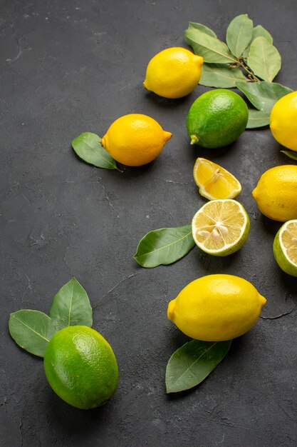 Вид спереди свежие лимоны кислые фрукты на темном фоне