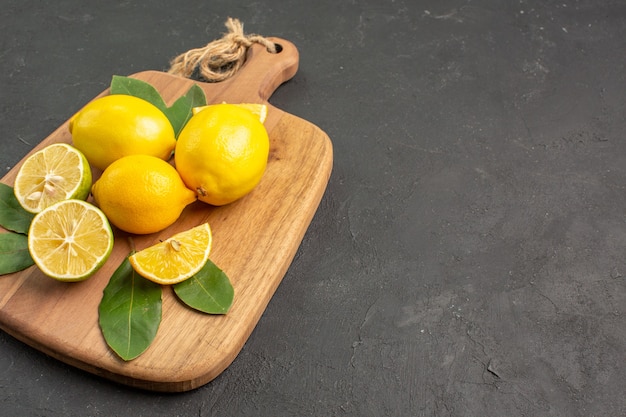 Вид спереди свежие лимоны кислые фрукты на темном фоне