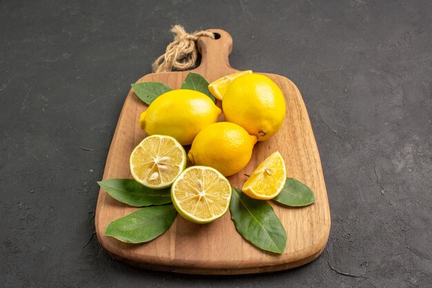 濃い灰色の背景に新鮮なレモン酸っぱい果物の正面図