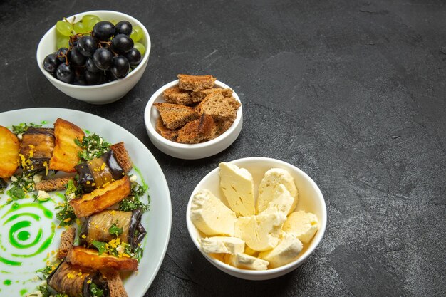 Front view fresh mellow grapes with white cheese eggplant rolls and sliced bread on dark background meal food dish milk fruits