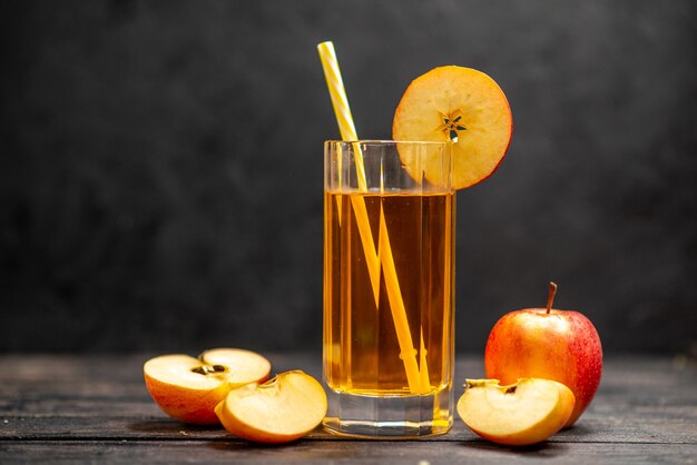 Вид спереди свежего натурального вкусного сока в двух стаканах с красным яблочным лаймом на черном фоне