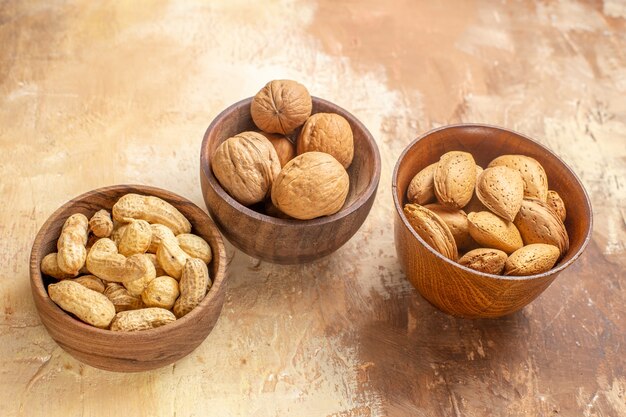 Вид спереди свежие орехи внутри тарелок на деревянном столе орех фундук арахис