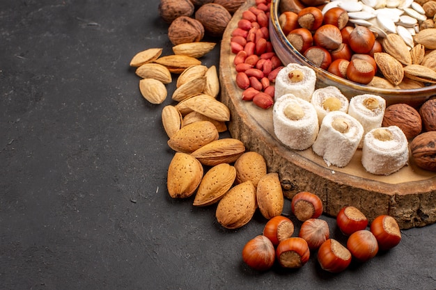 Front view of fresh nuts peanuts and other nuts on dark surface