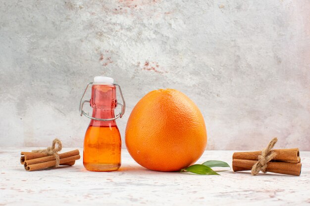 Front view fresh orange cinnamon sticks bottle on bright background free place