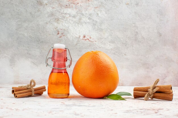 明るい背景のない場所に正面図新鮮なオレンジシナモンスティックボトル
