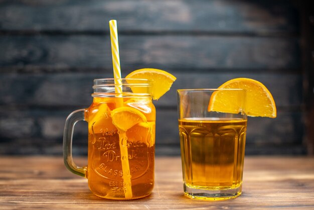 Вид спереди свежий апельсиновый сок внутри банки с трубочкой на темном баре для напитков фрукты фото цвет коктейля