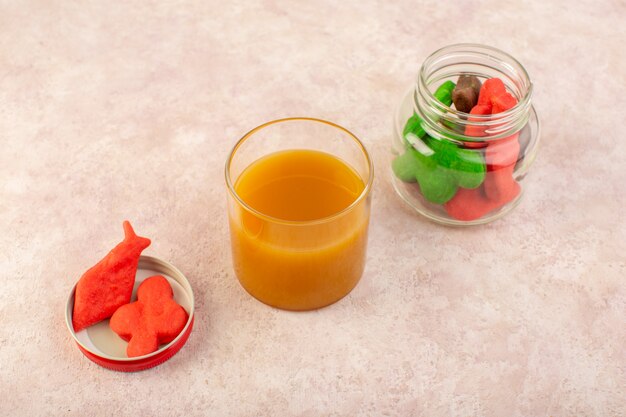 Вид спереди свежего персикового сока сладкого и вкусного с красочными печенье внутри банок