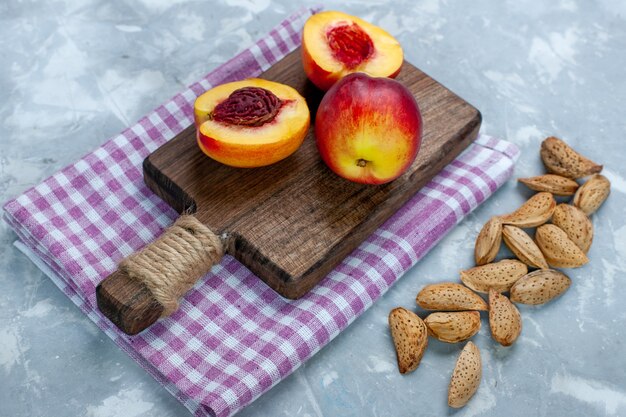 正面図新鮮な桃のまろやかでおいしい果物とナッツとライトホワイトの机