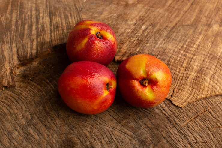 Free Photo front view fresh peaches orange colored on wooden desk