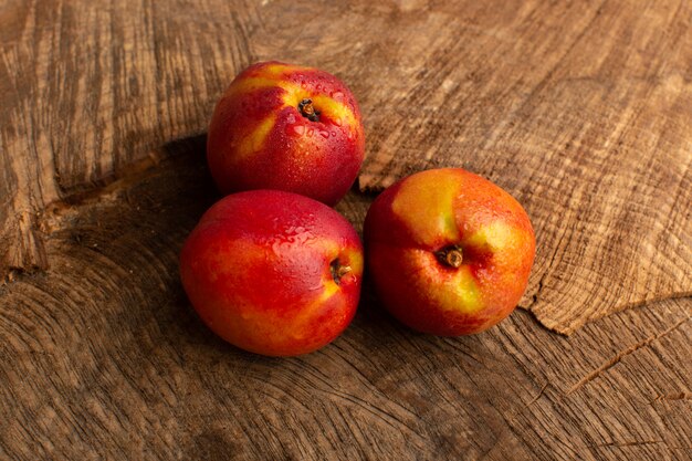 Front view fresh peaches orange colored on wooden desk