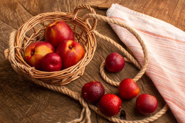 Front view fresh peaches and plums on wooden desk