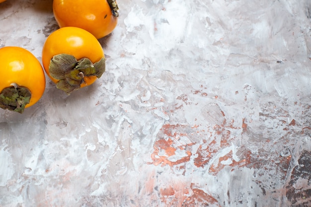 Free photo front view fresh persimmons on light table