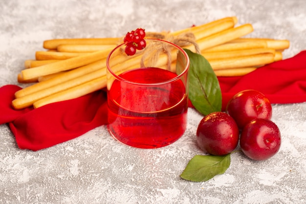 Front view fresh plums with plum juice and stick crackers