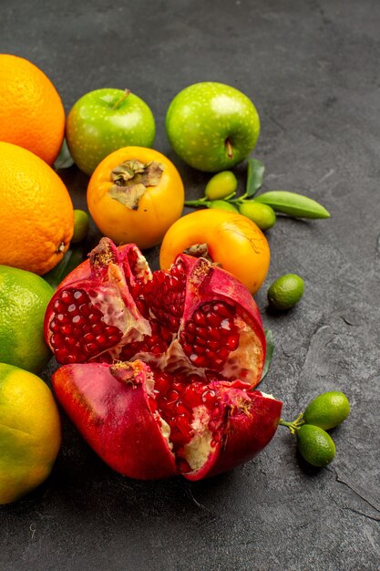 Вид спереди свежий гранат с яблоками и другими фруктами на серой поверхности цвета спелых фруктов