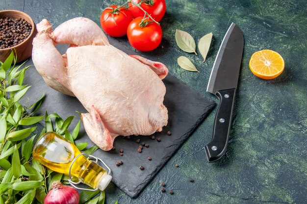Вид спереди свежая сырая курица с помидорами на темной кухне, ресторанная еда, фото животных, еда, цвет куриного мяса