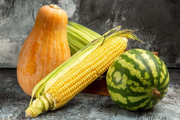 Foto gratuita mais crudo fresco vista frontale con melone e anguria su sfondo scuro-chiaro