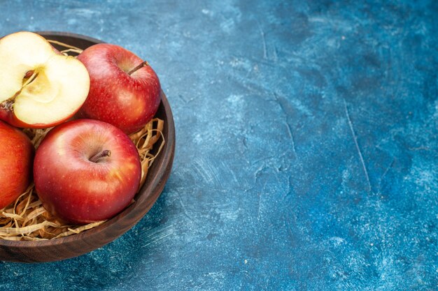 Front view fresh red apples inside plate on blue surface