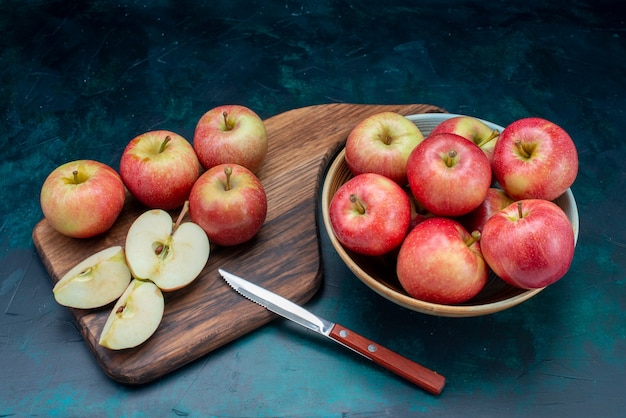 Вид спереди свежие красные яблоки сочные и спелые внутри тарелки на темно-синей поверхности фрукты свежие спелые спелые