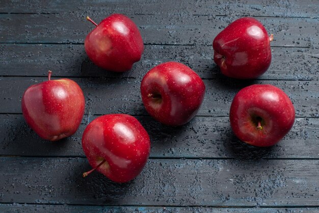 正面図新鮮な赤いリンゴは紺色の机の上のまろやかで熟した果物果物の色赤い植物ビタミン新鮮