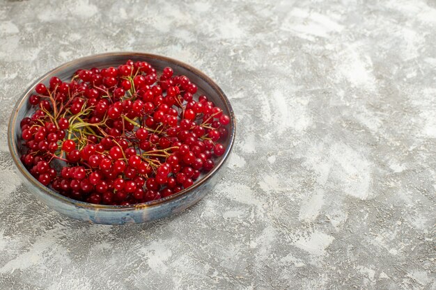 Front view fresh red cranberries inside tray on light white table berry color fruit wild red