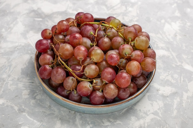 Free photo front view fresh red grapes juicy mellow sweet fruits on light-white desk fruit fresh mellow juice wine