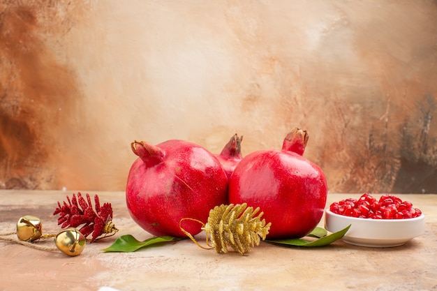 Front view fresh red pomegranates on light background color fruit photo mellow juice