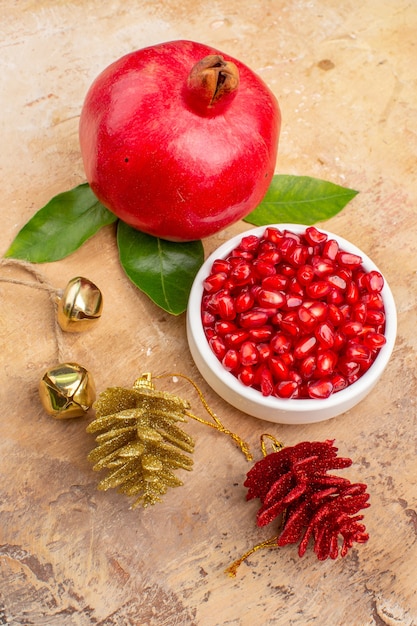 Free photo front view fresh red pomegranates peeled and with whole fruits on light background color fruit photo mellow juice