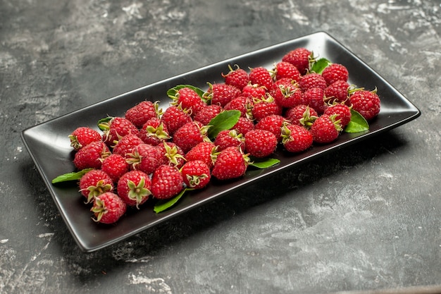 Front view fresh red raspberries inside black pan on grey fruit color cranberry wild photo berry