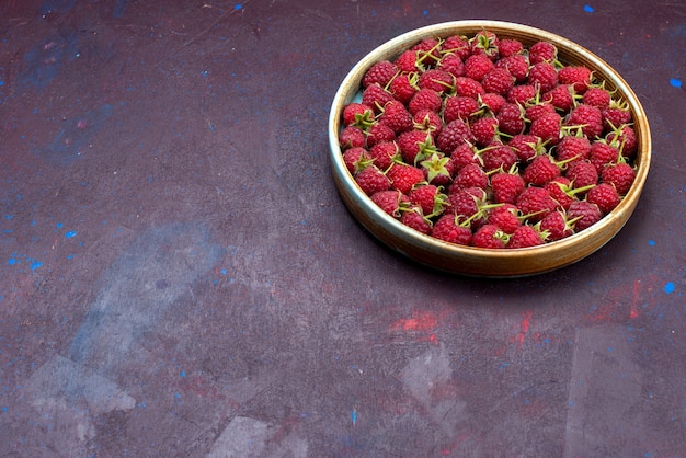 正面図紺色の背景に熟した酸っぱいベリーの新鮮な赤いラズベリーベリーフルーツまろやかな夏の食べ物のビタミン