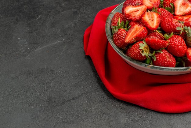 Вид спереди свежая красная клубника внутри тарелки на темном фоне летнего цвета сок дерева ягода дикая свободное пространство