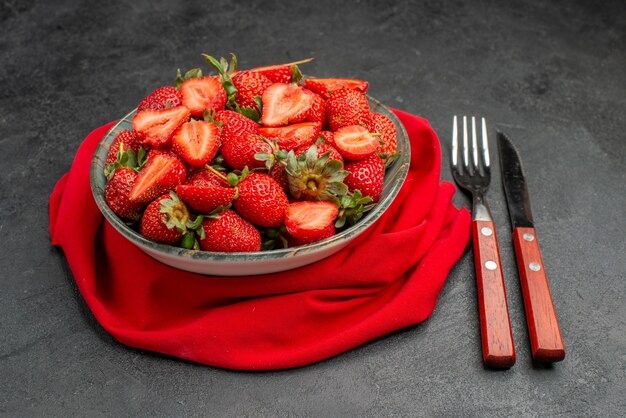 Front view fresh red strawberries inside plate with cutlery on dark background summer color tree juice berry wild