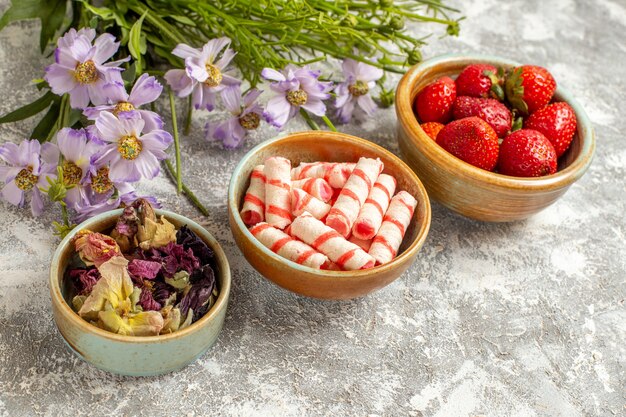 흰색 표면 베리 과일 빨간 사탕에 꽃과 전면보기 신선한 빨간 딸기