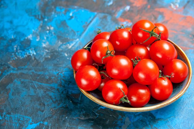 正面図青いテーブルのプレート内の新鮮な赤いトマト