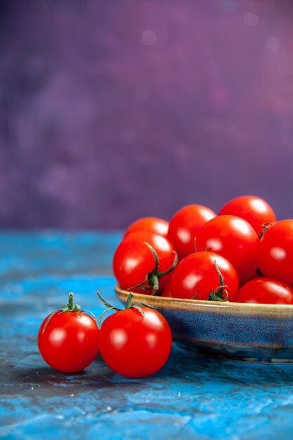 Front view fresh red tomatoes inside plate on blue table