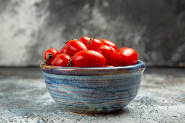 어두운 빛 배경에 접시 안에 전면보기 신선한 빨간 토마토
