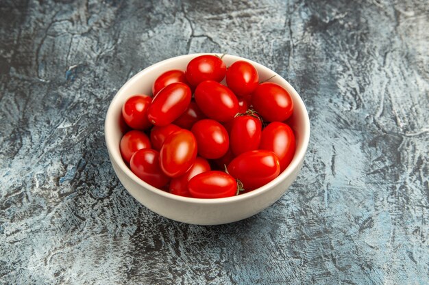 Pomodori rossi freschi di vista frontale all'interno della zolla sui precedenti scuro-chiari