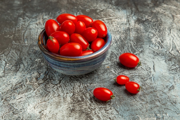 어두운 빛 배경에 접시 안에 전면보기 신선한 빨간 토마토