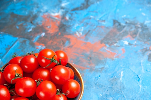 무료 사진 파란색 테이블에 있는 접시 안에 있는 신선한 빨간 토마토 전면 보기