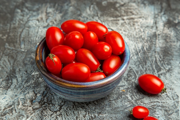 Бесплатное фото Вид спереди свежие красные помидоры внутри тарелки на темно-светлом фоне