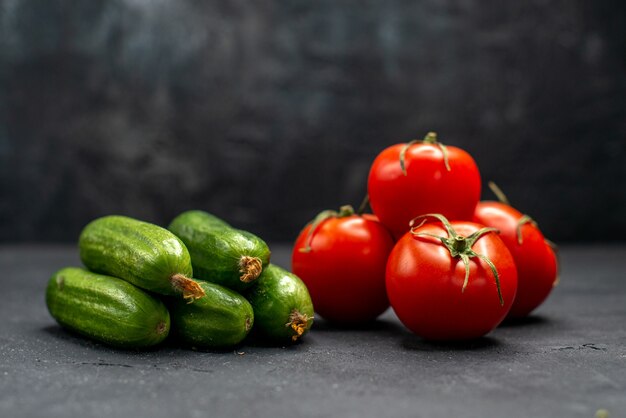 Front view fresh red tomatoes with cucumbers on dark background ripe meal color photo salad