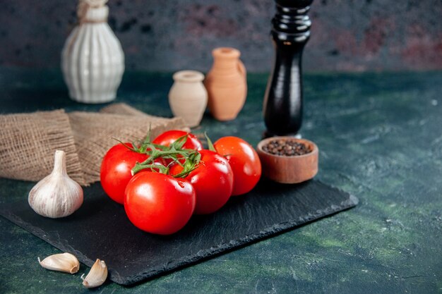 어두운 배경에 마늘과 전면보기 신선한 빨간 토마토